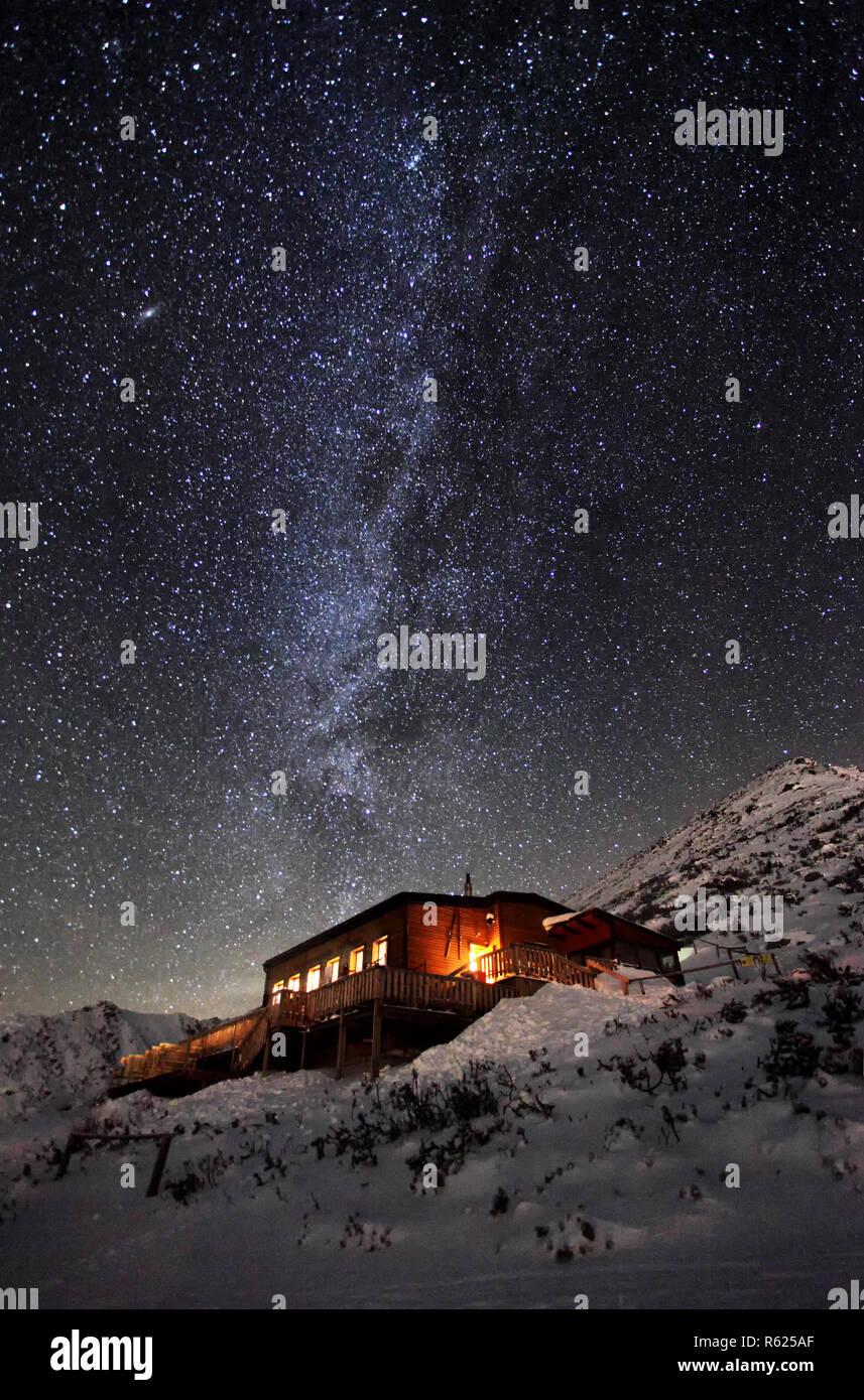 Milky way over winter mountain landscape with cottage, Slovakia Tatras Stock Photo