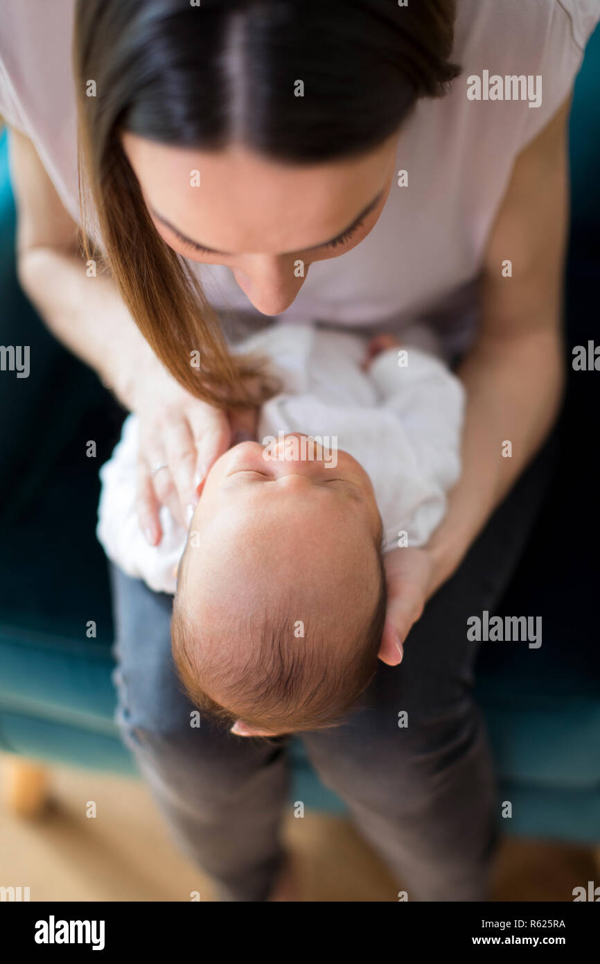 Overhead View Of Mother Cuddling Newborn Baby Son At Home Stock Photo