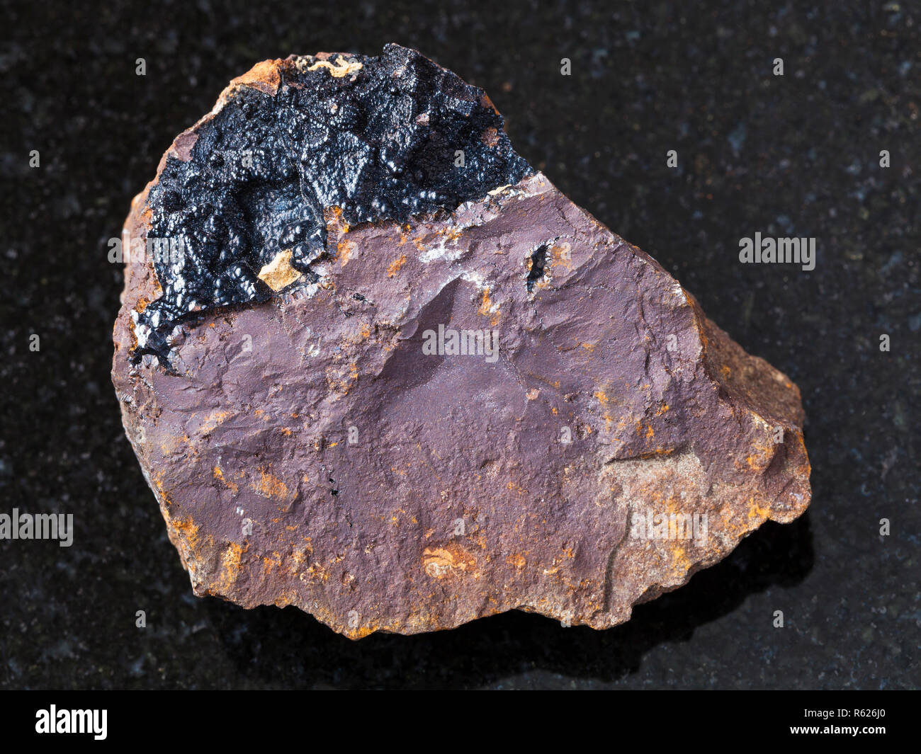 goethite aggregates on limonite stone on dark Stock Photo