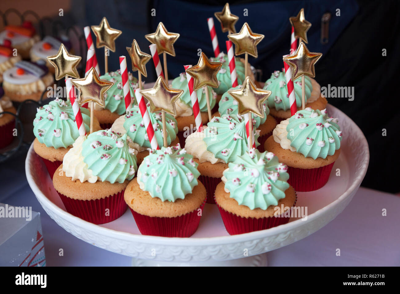 Cup cakes decorated with cream, candy canes and golden stars Stock Photo