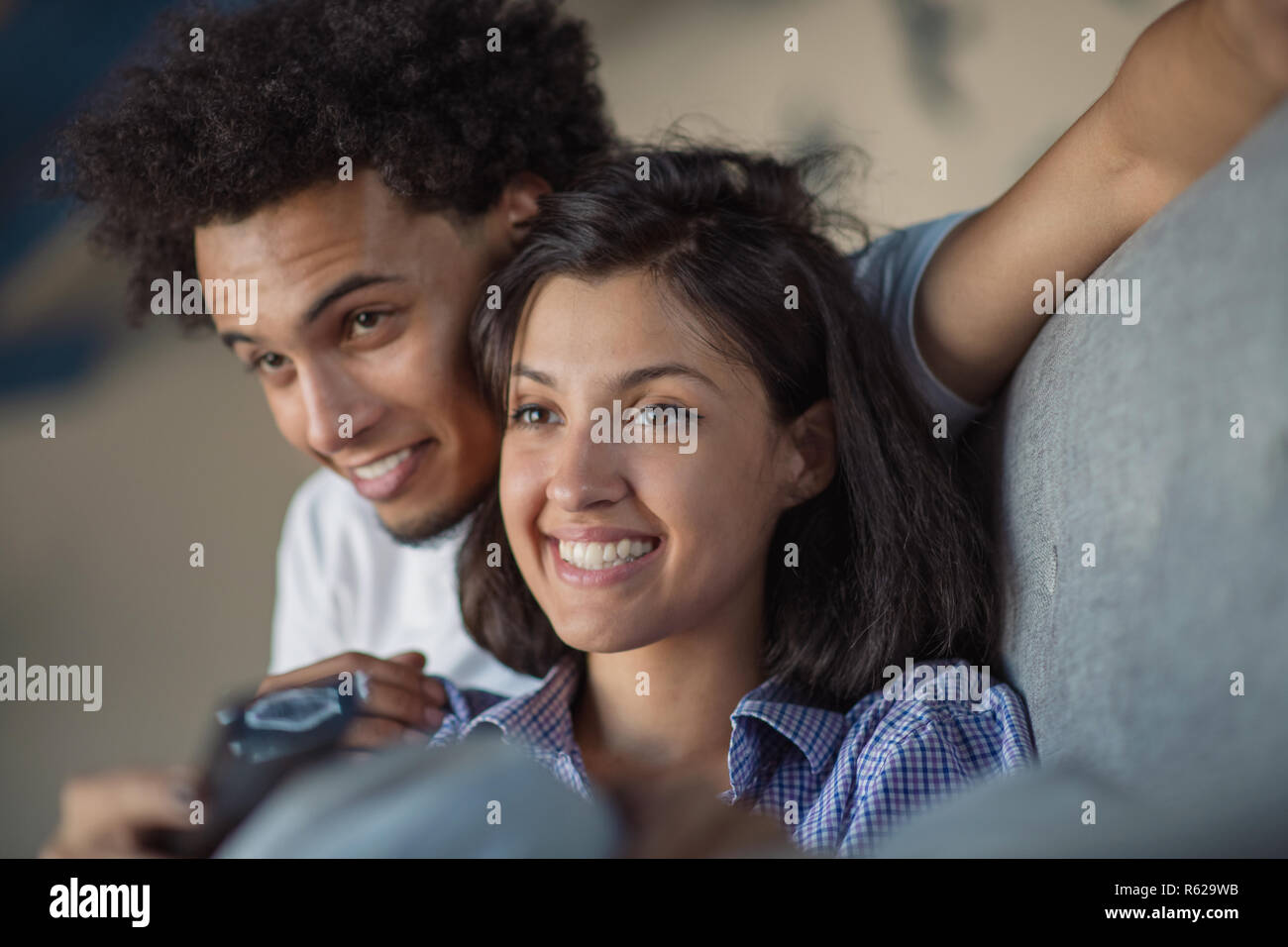 Young black couple relaxing on couch and smiling at camera Stock Photo ...