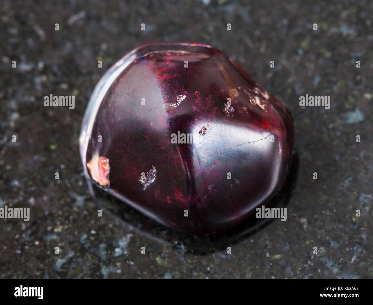 polished red garnet gemstone on dark background Stock Photo - Alamy
