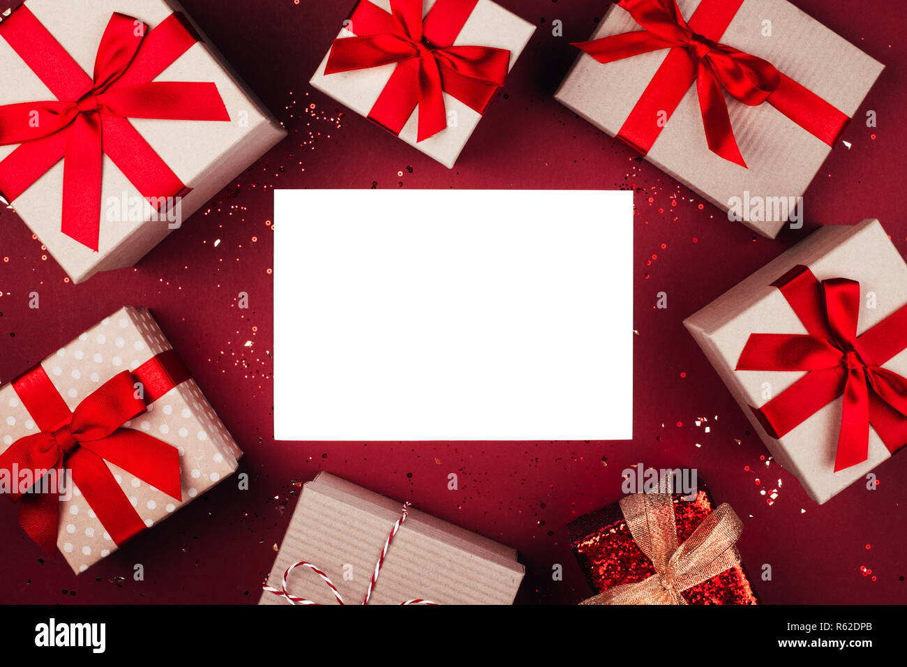 Many present boxes with red bow on red background. Flat lay style. Stock Photo