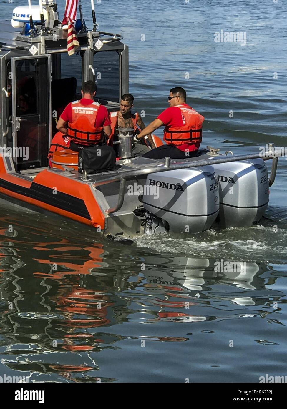 A Coast Guard 29-foot Special Purpose Craft-Shallow Water boat crew from Station Fort Myers Beach and Lee County EMS personnel are shown Tuesday, May 9, 2017 with a 28-year-old man (center) in need of medical attention aboard the SPC-SW near Estero Bay, Florida. The man was medevacked from the sailboat Anna Maria due to suffering from abdominal pain and transferred to EMS on shore in stable condition. Stock Photo