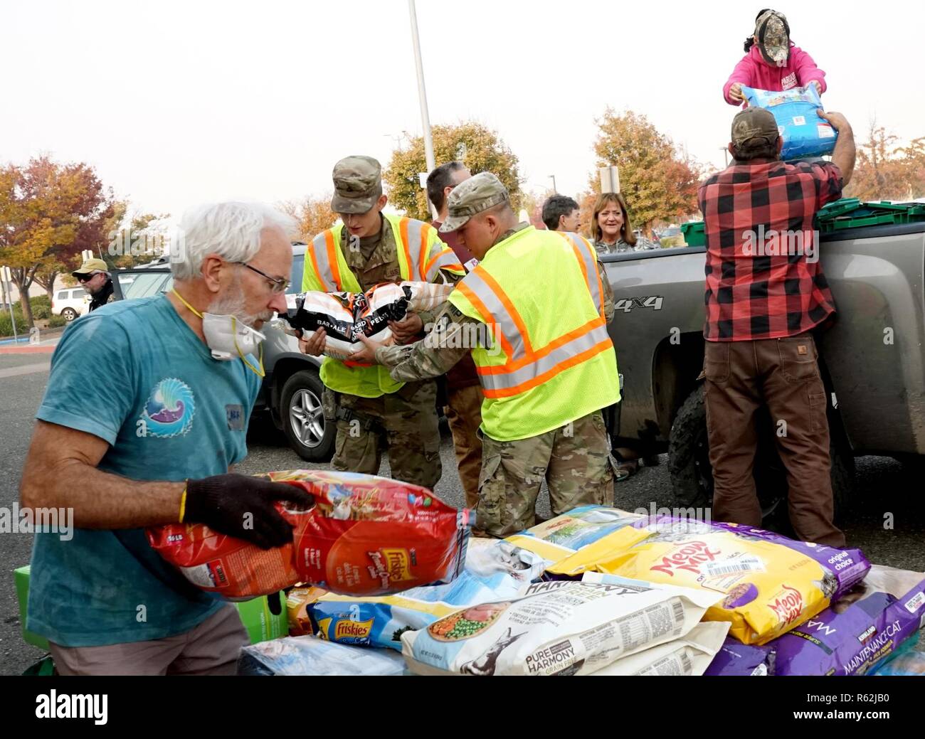 Spc. Mark Maynard and Pfc. Christian P. Reinke, military police officers with the 870th Military Police Company, helps local community members unload donations at a temporary animal shelter at the municipal airport in Chico, California, Nov. 18, 2018. In response to the Camp Fire, the airport has been converted to a temporary animal shelter, caring for displaced animals and providing donations to pet owners in need. Stock Photo