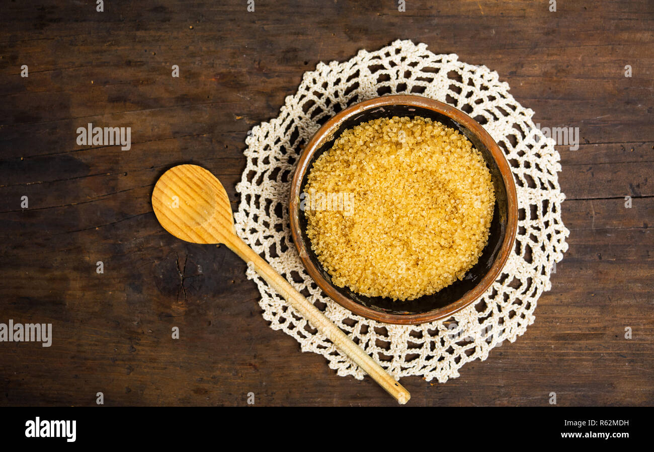 Brown sugar in a bowl on a wooden table top view Stock Photo