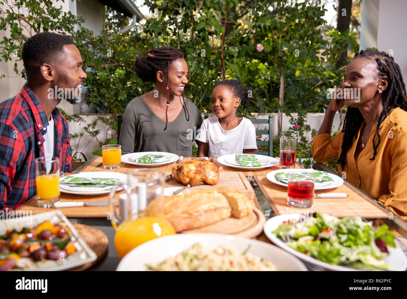 An African family sitting around a table for lunch Stock Photo
