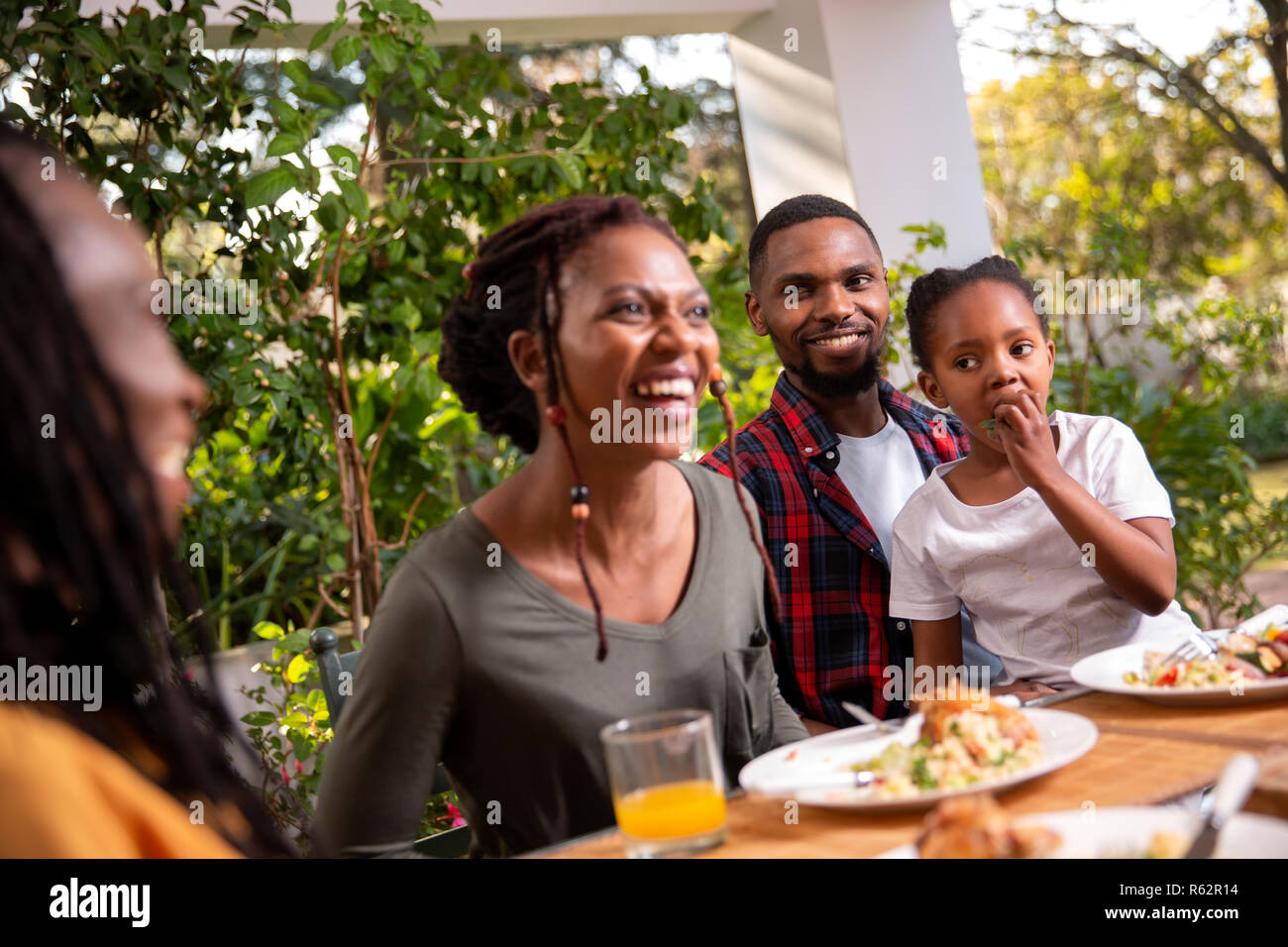 A family eating lunch together on a patio Stock Photo