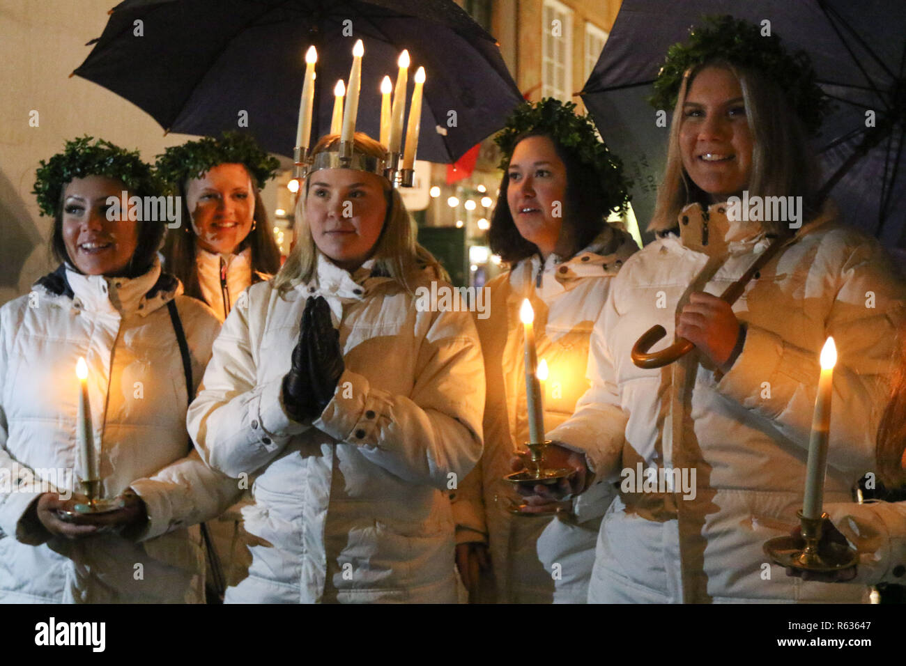 Gdansk, Poland 3rd. December 2018 Young girls from Kalmar, Sweden dressed in a white dress and a red sash (as the symbol of martyrdom) carrying candles singing in the Gdansk Old City centre. Swedish girls dressed as Saint Lucy (Sankta Lucia)  carry cookies in procession and sing a songs. It is said that to vividly celebrate St. Lucy's Day will help one live the long winter days with enough light  Credit: Max Ardulf/Alamy Live News Stock Photo