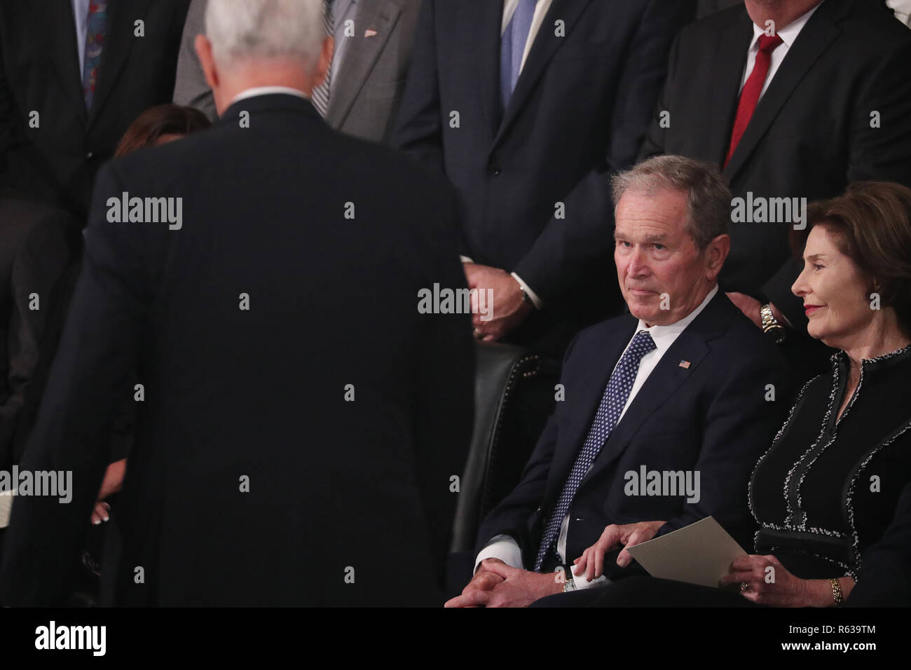 Washington, United States Of America. 03rd Dec, 2018. Former U.S. President George W. Bush looks up at Vice President Mike Pence as he walks back to his seat past Bush and his wife former first lady Laura Bush after Pence spoke about the president's father former President George H.W. Bush during ceremonies in the U.S. Capitol Rotunda in Washington, U.S., December 3, 2018. REUTERS/Jonathan Ernst/Pool | usage worldwide Credit: dpa/Alamy Live News Stock Photo