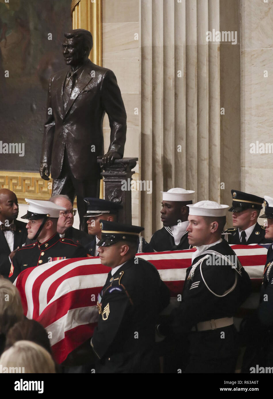Washington, District of Columbia, USA. 3rd Dec, 2018. A U.S. military honor guard carries the casket of former U.S. President George H.W. Bush past the statue of former President Ronald Reagan as it arrives to lie in state in the U.S. Capitol Rotunda in Washington, U.S., December 3, 2018. REUTERS/Jonathan Ernst/Pool Credit: Jonathan Ernst/CNP/ZUMA Wire/Alamy Live News Stock Photo