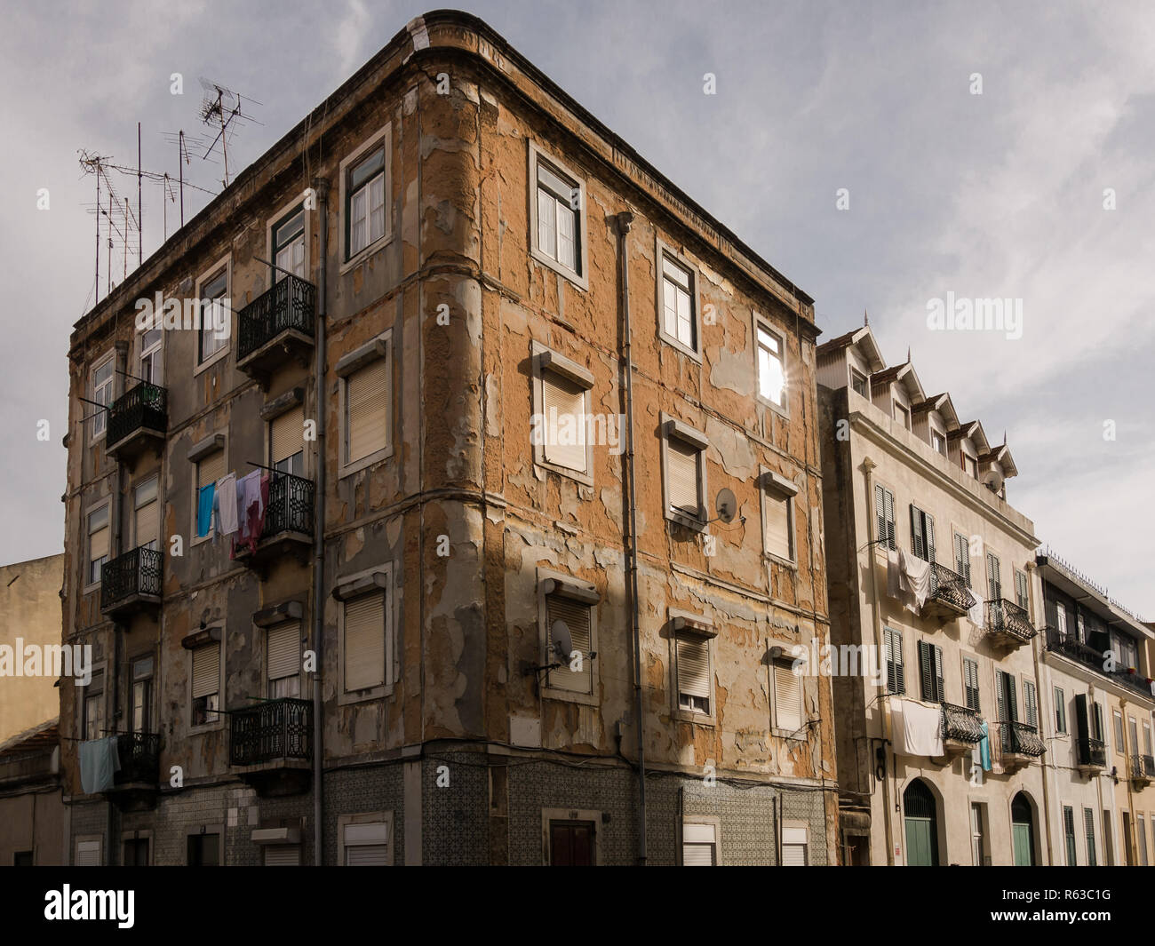 Dilapidated worn classic apartment building facade in city street Stock