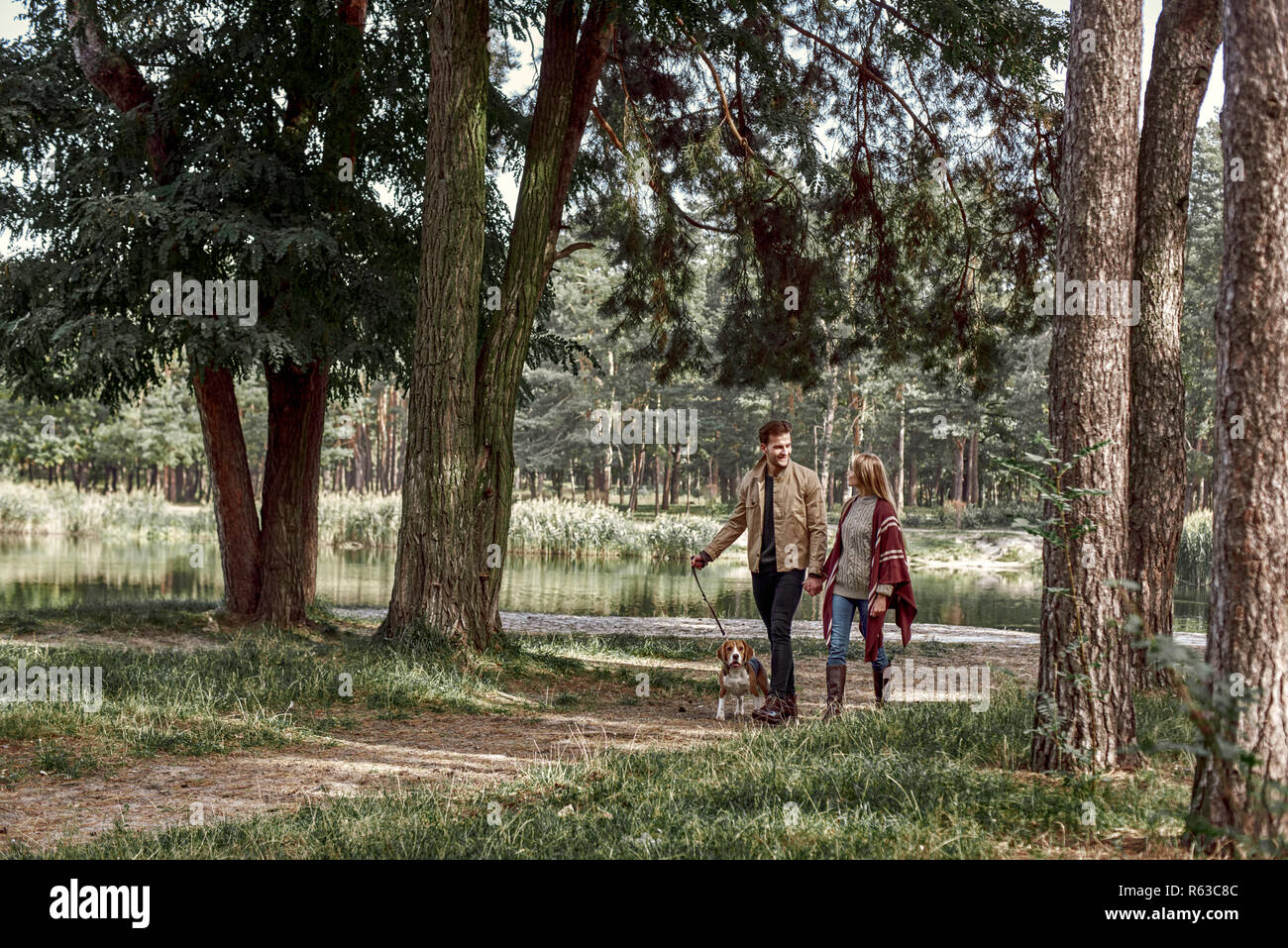 Young couple are walking with dog in forest Stock Photo - Alamy