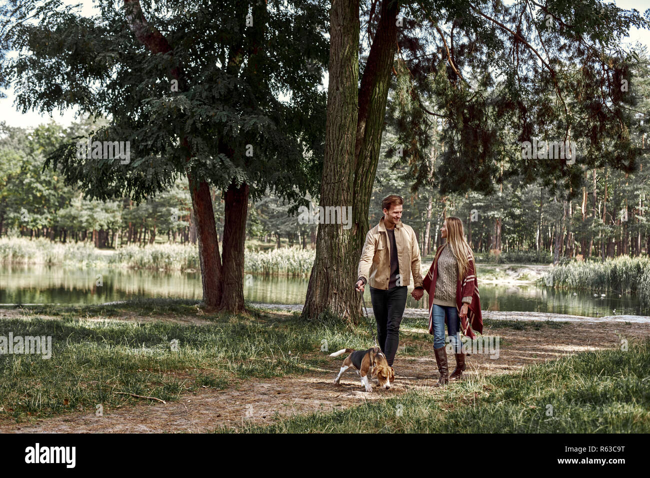 Young couple are walking with dog in forest Stock Photo - Alamy