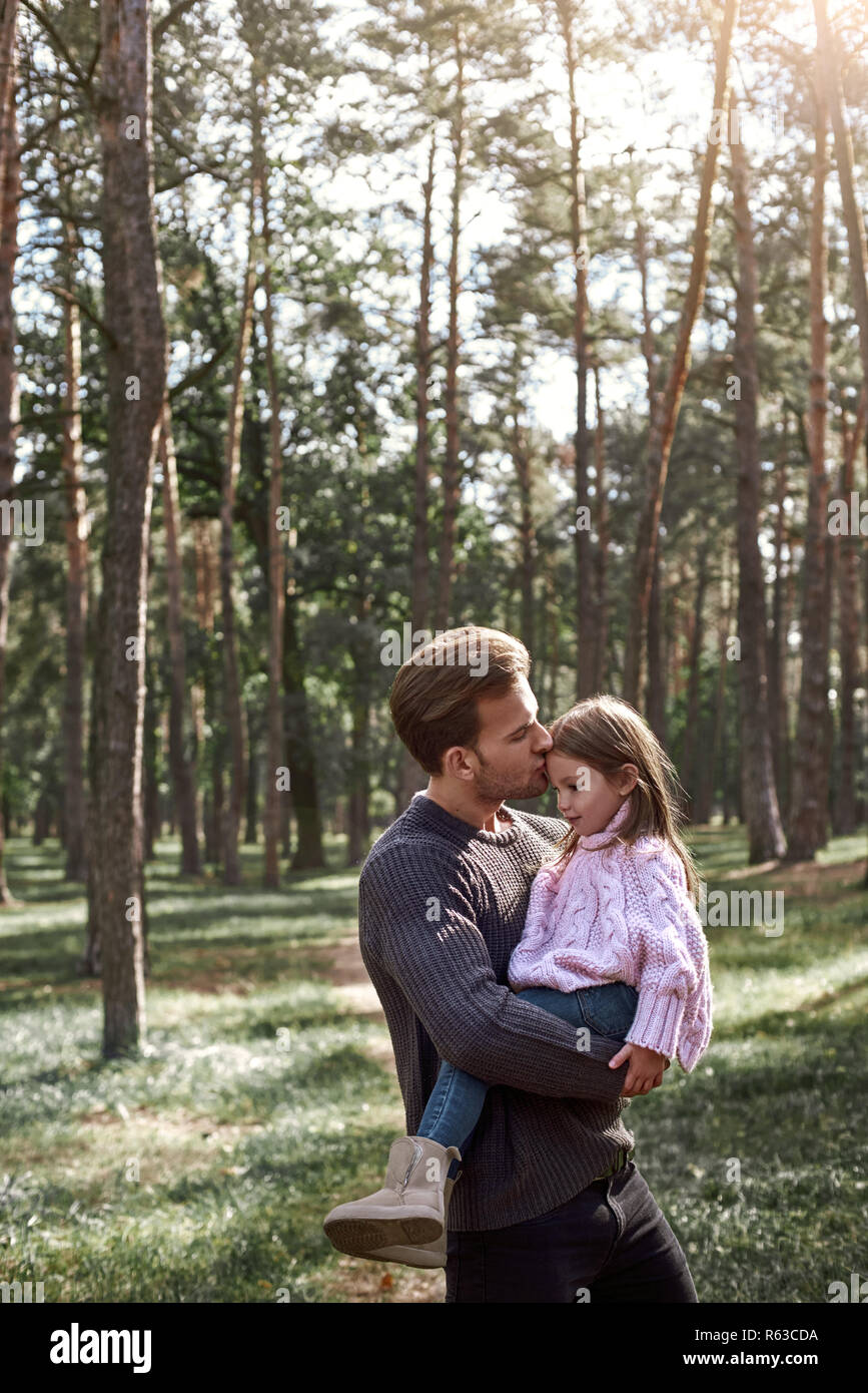A father kisses his little pretty daughter in forest Stock Photo - Alamy