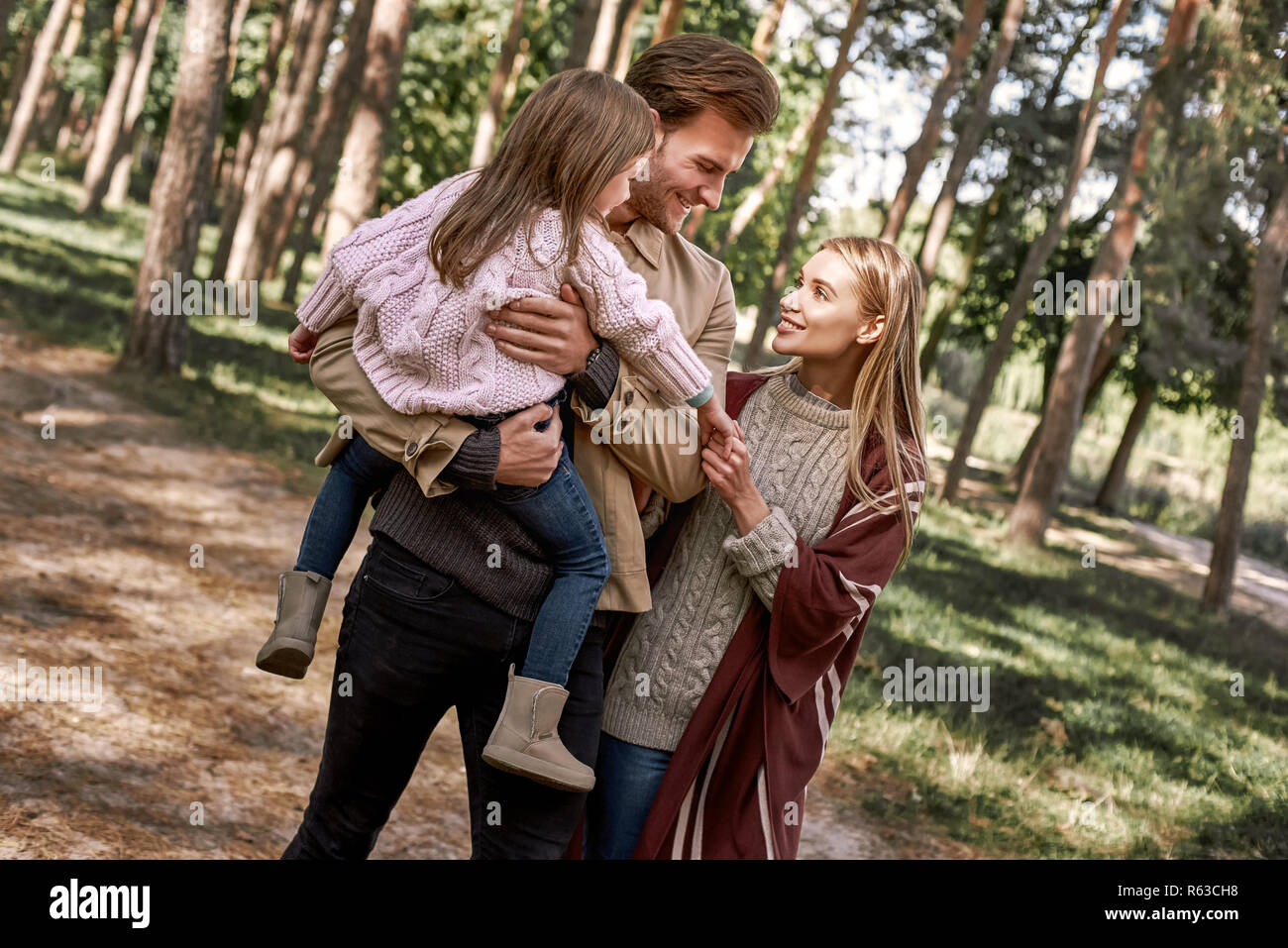 Young parents with little daughter in autumn forest. Stock Photo