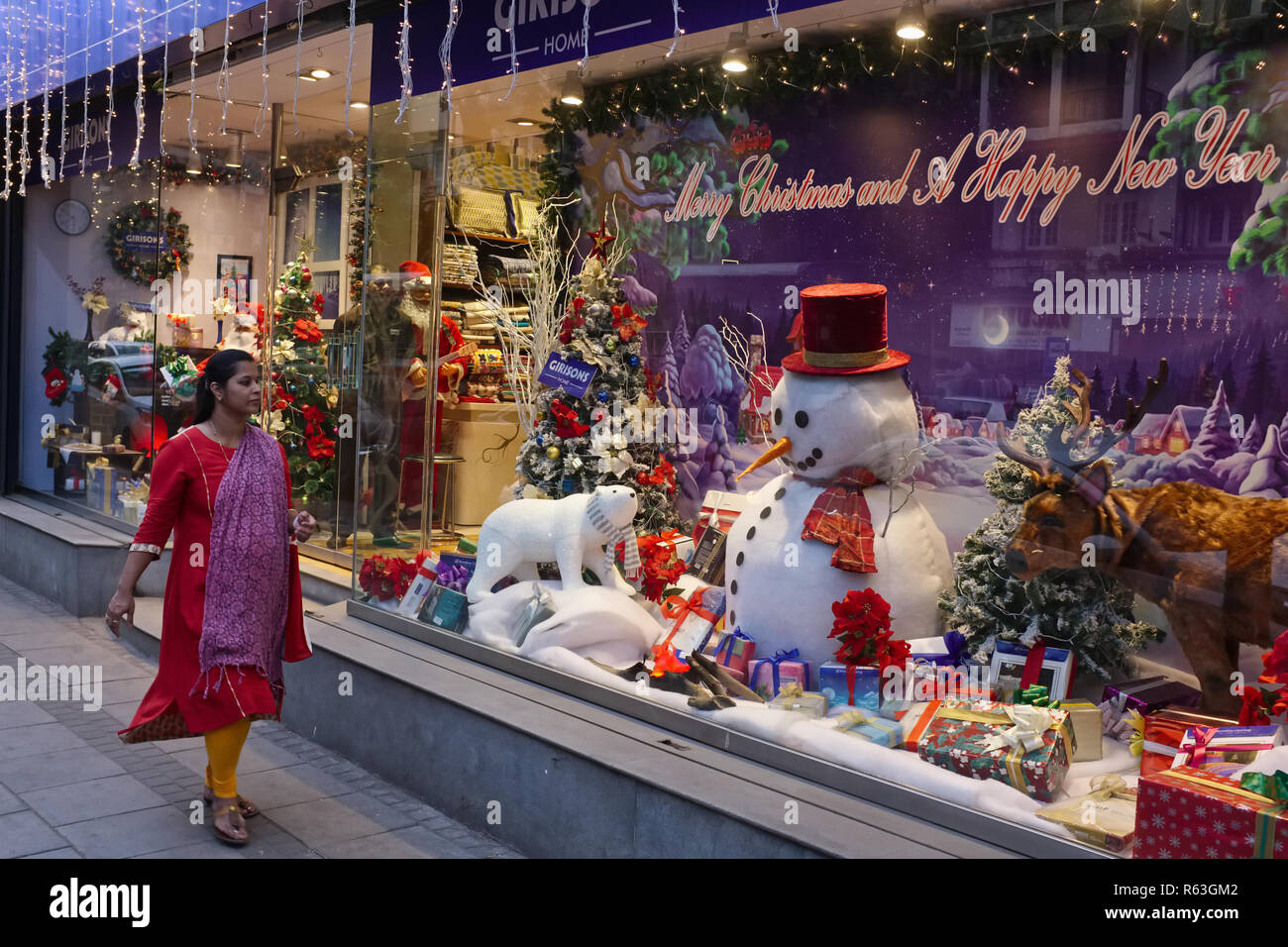 A woman walks past a shop in Mumbai, India, decorated for Christmas, the country's Christian minority's most important holiday Stock Photo