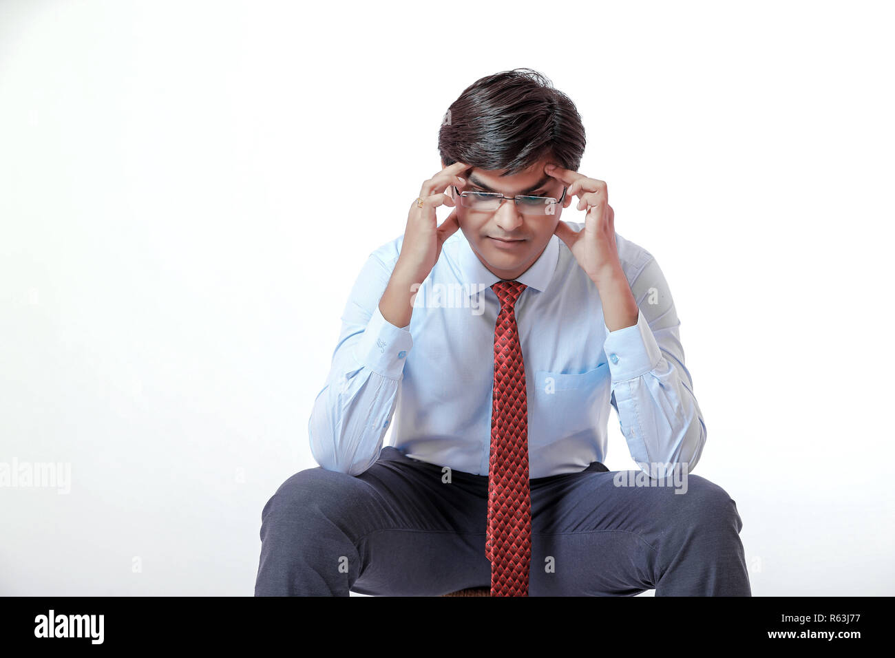 Young indian businessman with headache over white background Stock Photo