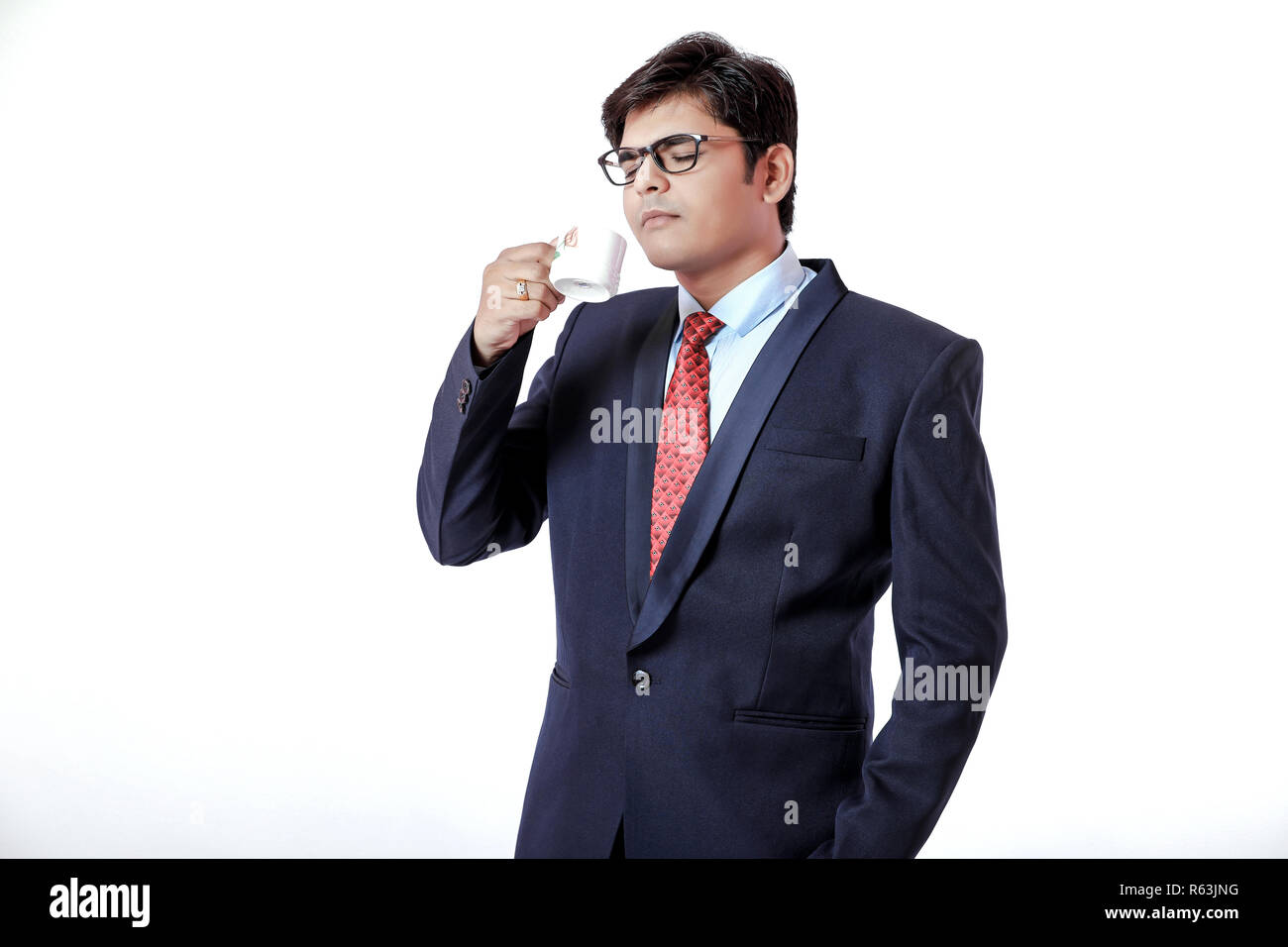 Young Indian businessman drinking a coffee over white background Stock Photo