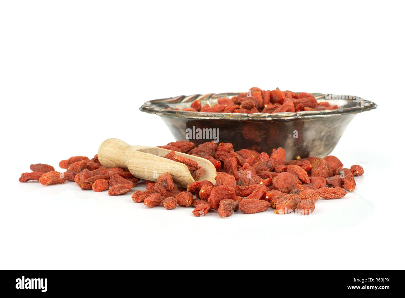 Set of lot of whole dried red goji berries in old iron bowl isolated on