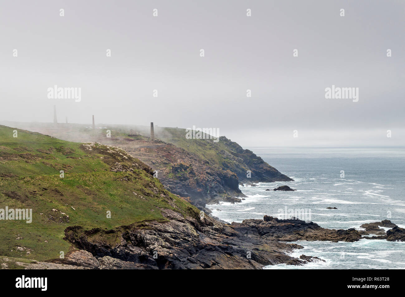 Mist Swirling Around the Chimneys and Spoil Heaps of the Abandoned Levant Mines, Botallack, St Just, Cornwall, UK Stock Photo