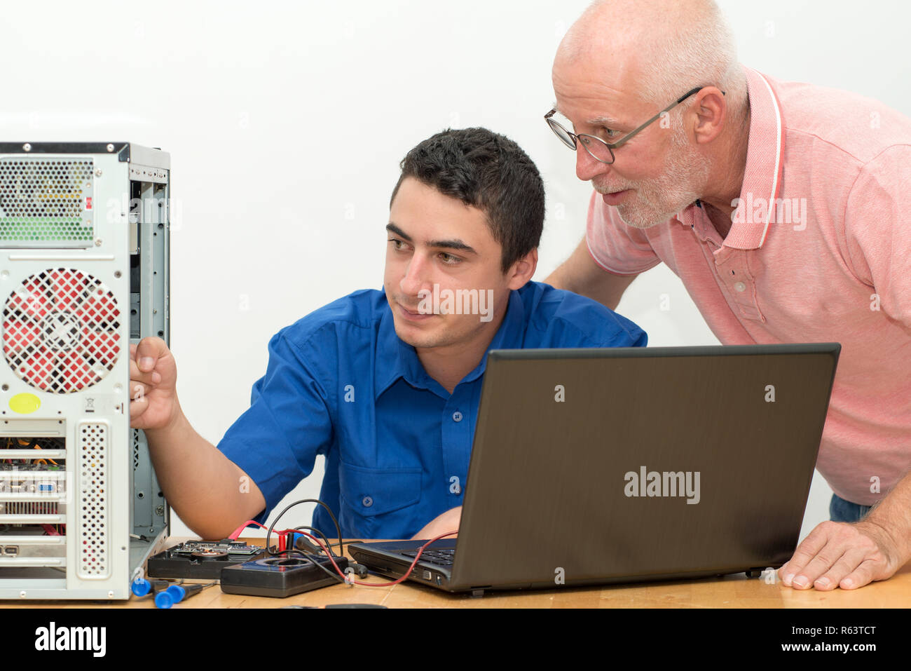 two technicians working on broken computer in workshop Stock Photo