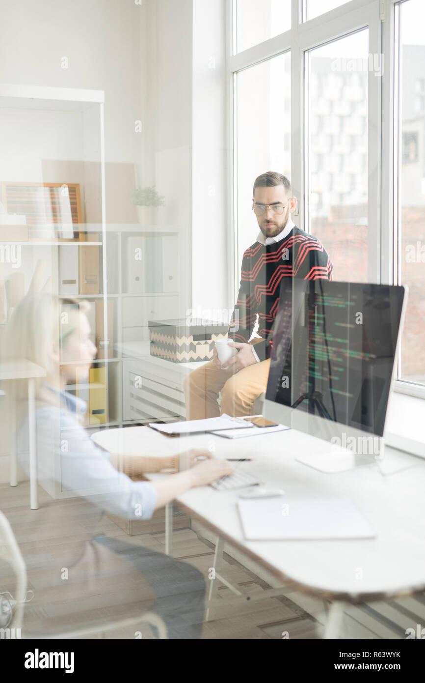 Serious manager talking to coder in office Stock Photo