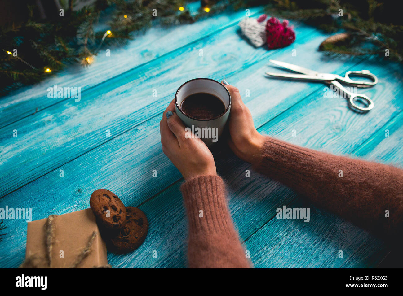 Girl holding a cup of hot cocoa on christmas blue background. Stock Photo