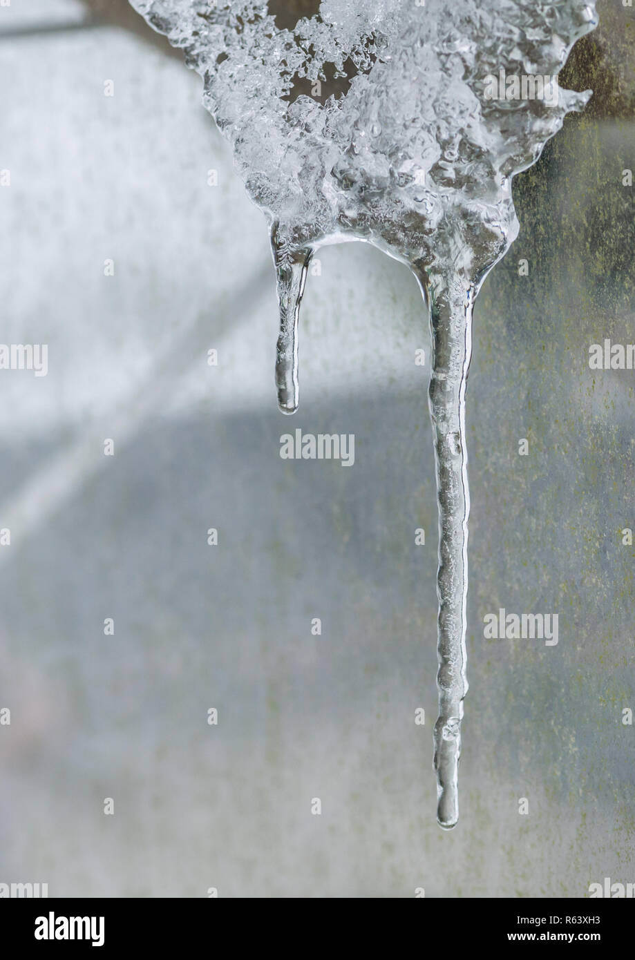 A macro shot of icicles descending from a rooftop. Stock Photo
