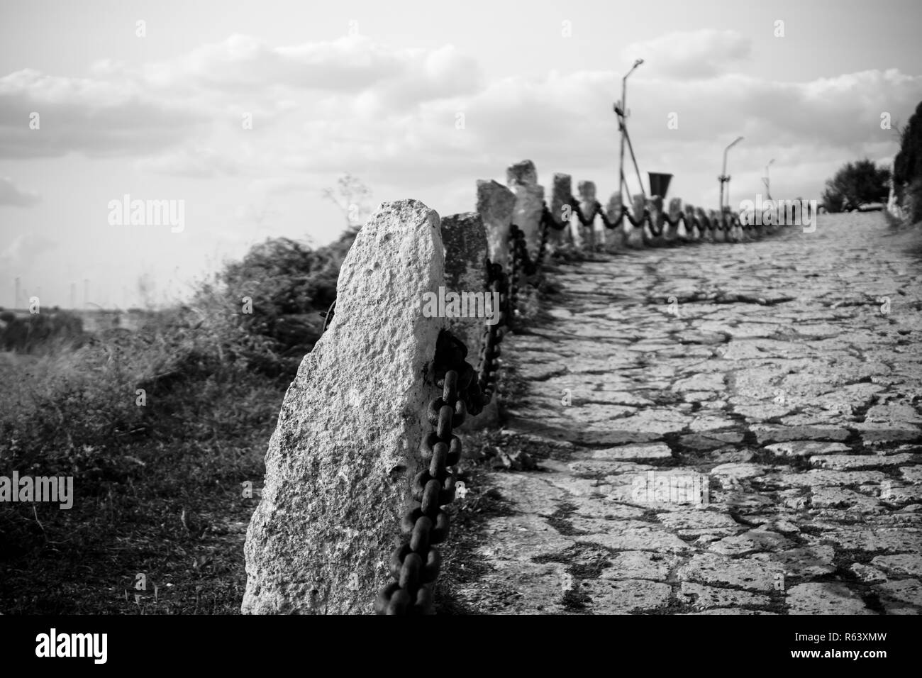 The old stone road leaving into the distance. Black and white. Stock Photo