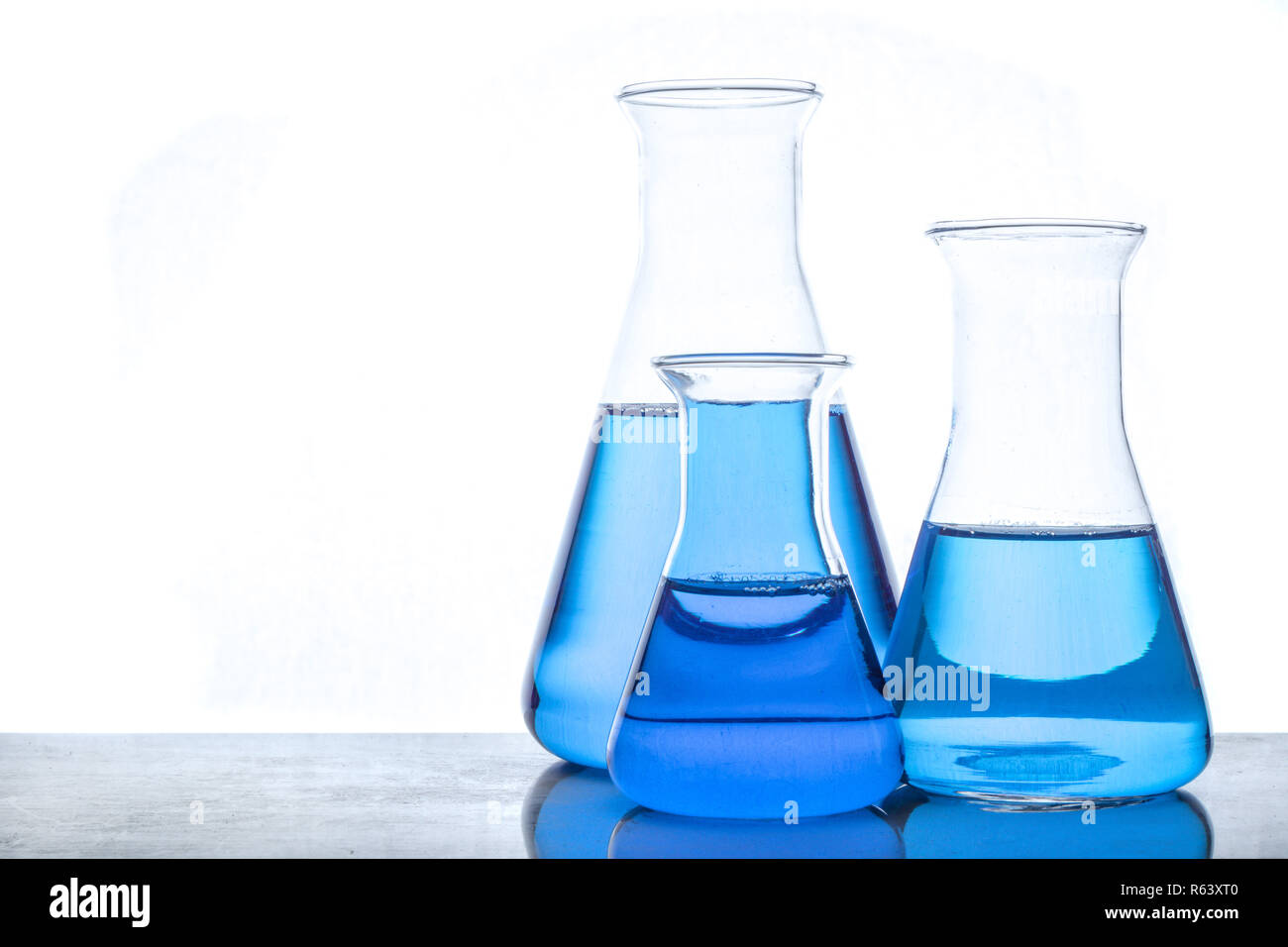 Glass flasks with blue fluid in used in chemistry experiments Stock