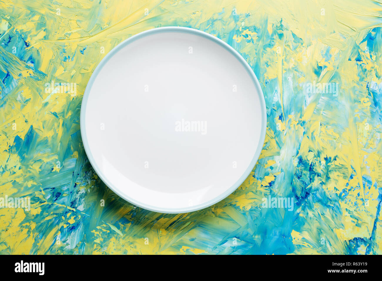 Empty ceramic round plate on colorful background with copy space. Stock Photo