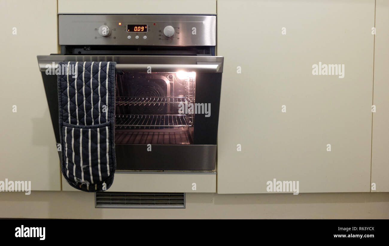 An electric oven installed into a white with the door opened