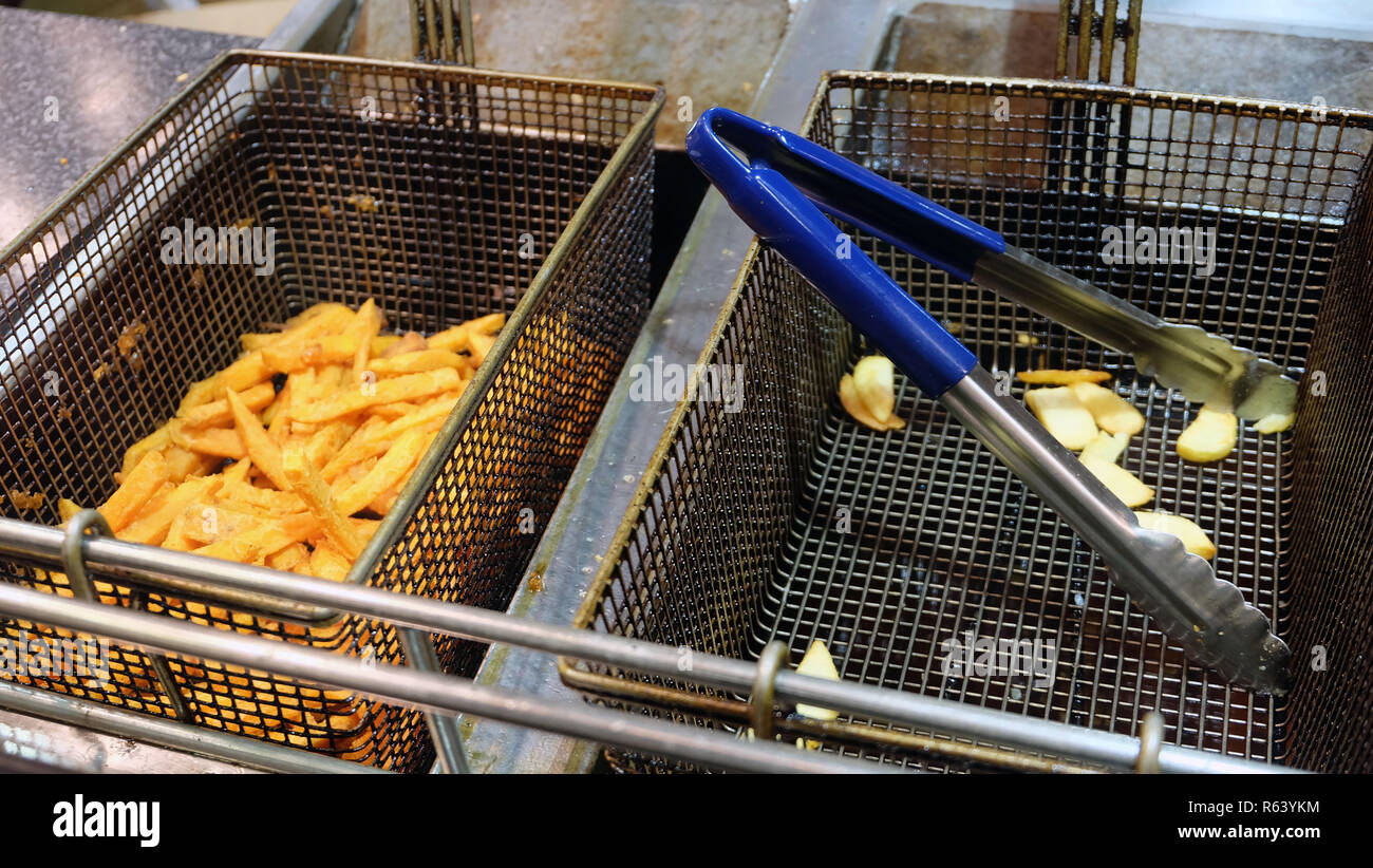 https://c8.alamy.com/comp/R63YKM/two-deep-fryer-baskets-side-by-side-one-with-golden-french-fries-and-the-other-with-a-kitchen-tongs-R63YKM.jpg