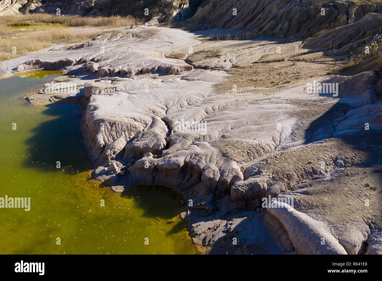 Aerial shot of abandoned opencast mine and waste lake. Abstract cracked ...