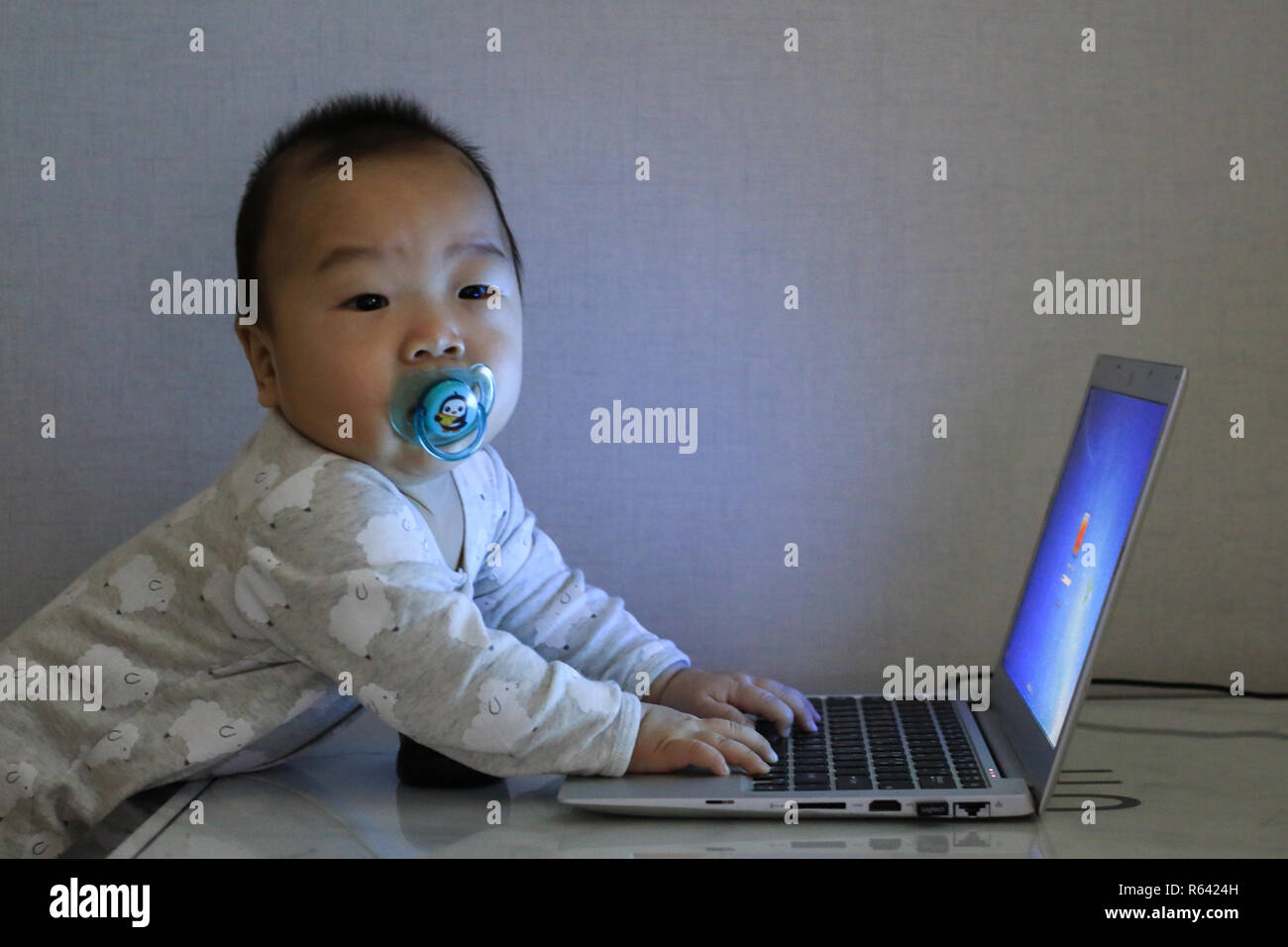 asian baby working with laptop in the darkness Stock Photo - Alamy
