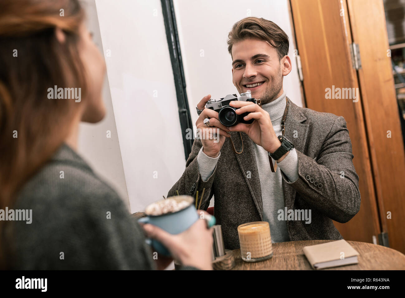 Man photographing woman while sitting in a cafe Stock Photo