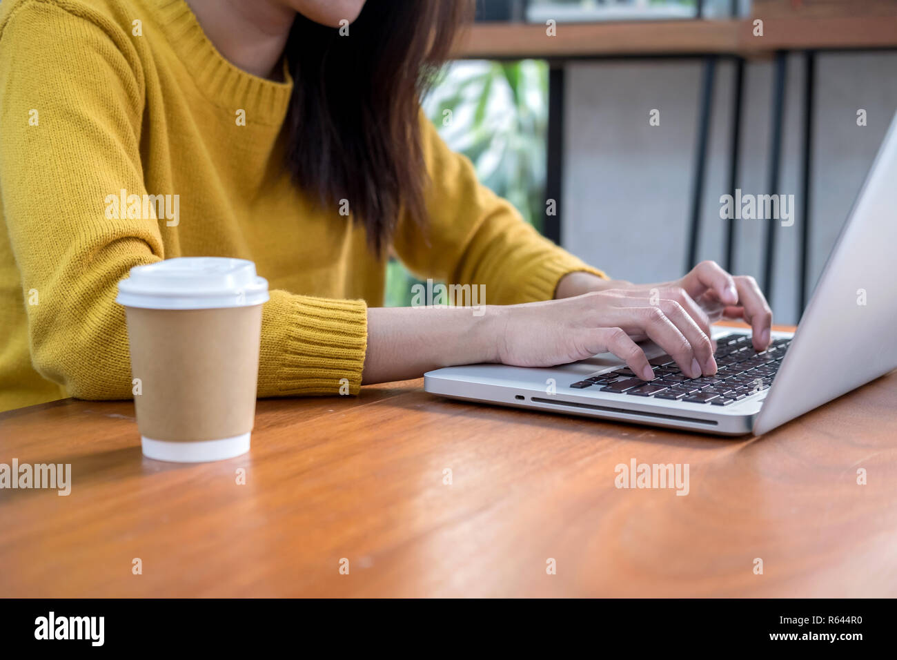 Online business concept. Woman hand using computer laptop in coffee shop. Stock Photo