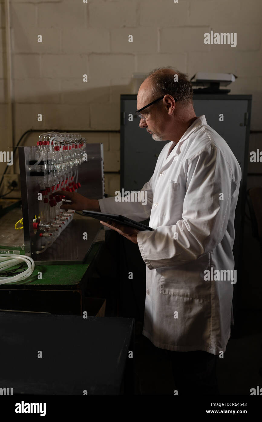 Worker working while using digital tablet in factory Stock Photo