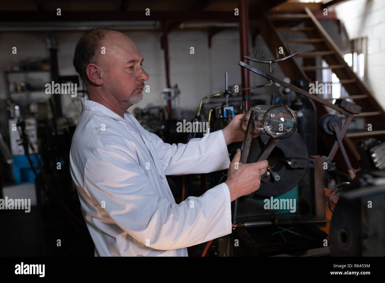 Male worker examining glass product in glass factory Stock Photo