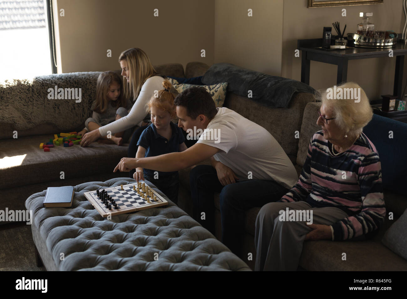 Multi generation family playing games on sofa in living room Stock Photo