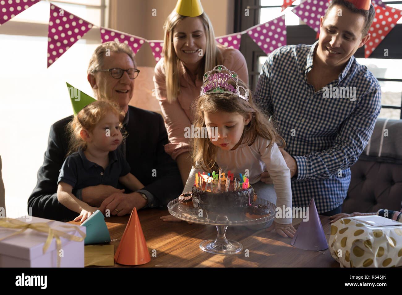 Multi-generation family celebrating birthday in living room Stock Photo