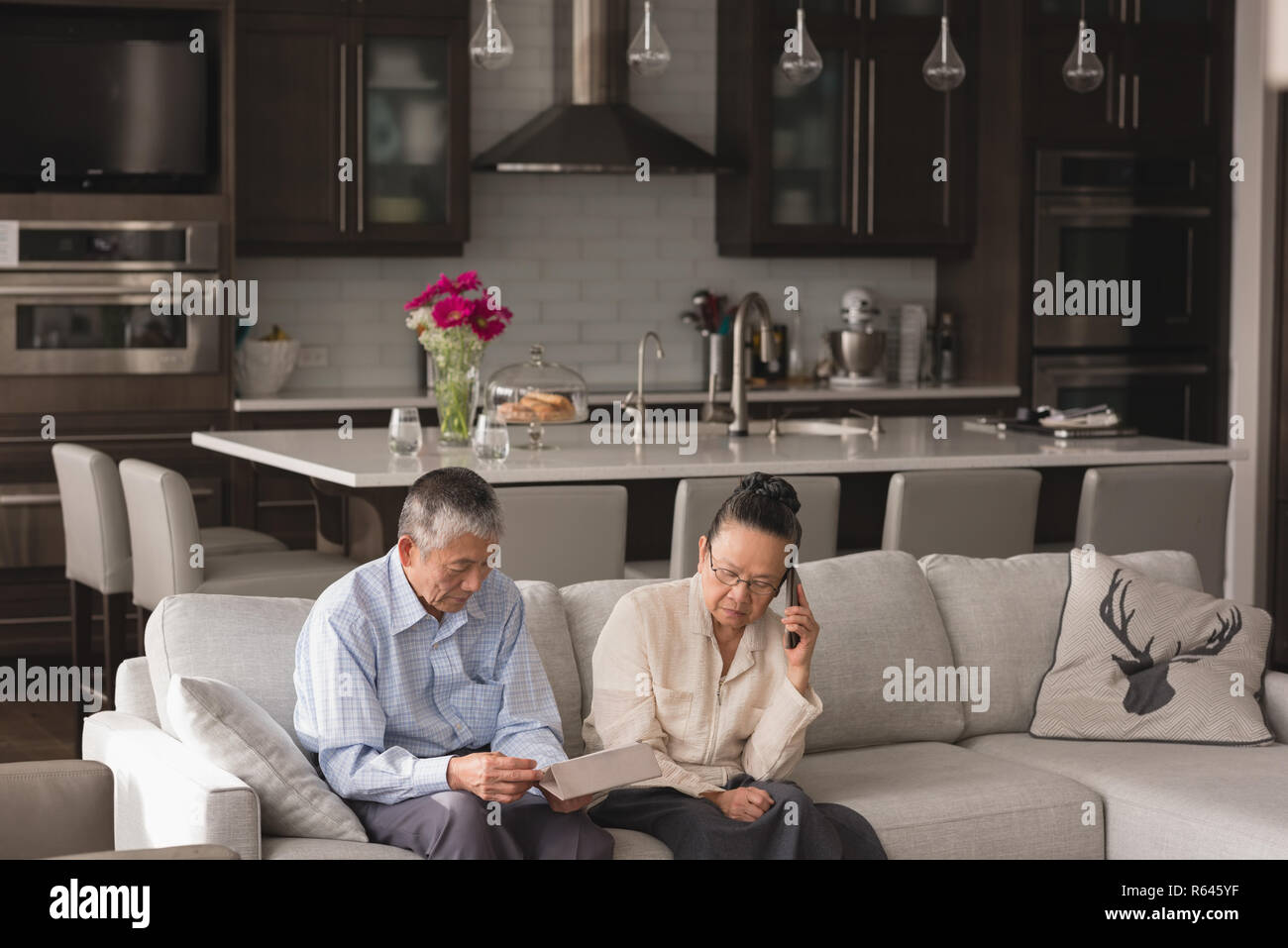 Senior couple using digital tablet and talking on mobile phone Stock Photo