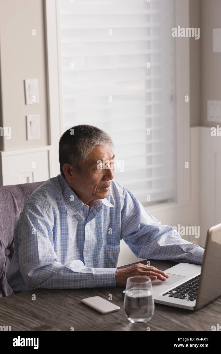 Senior man using laptop on table Stock Photo