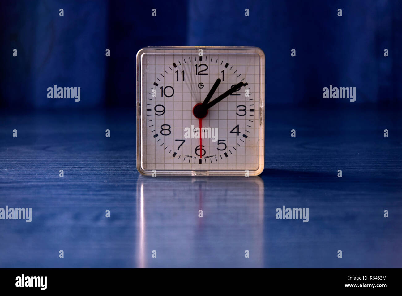 Analog quartz clock showing in 5 second exposure by time lapse the moving of the second hand, close-up in blue environment Stock Photo