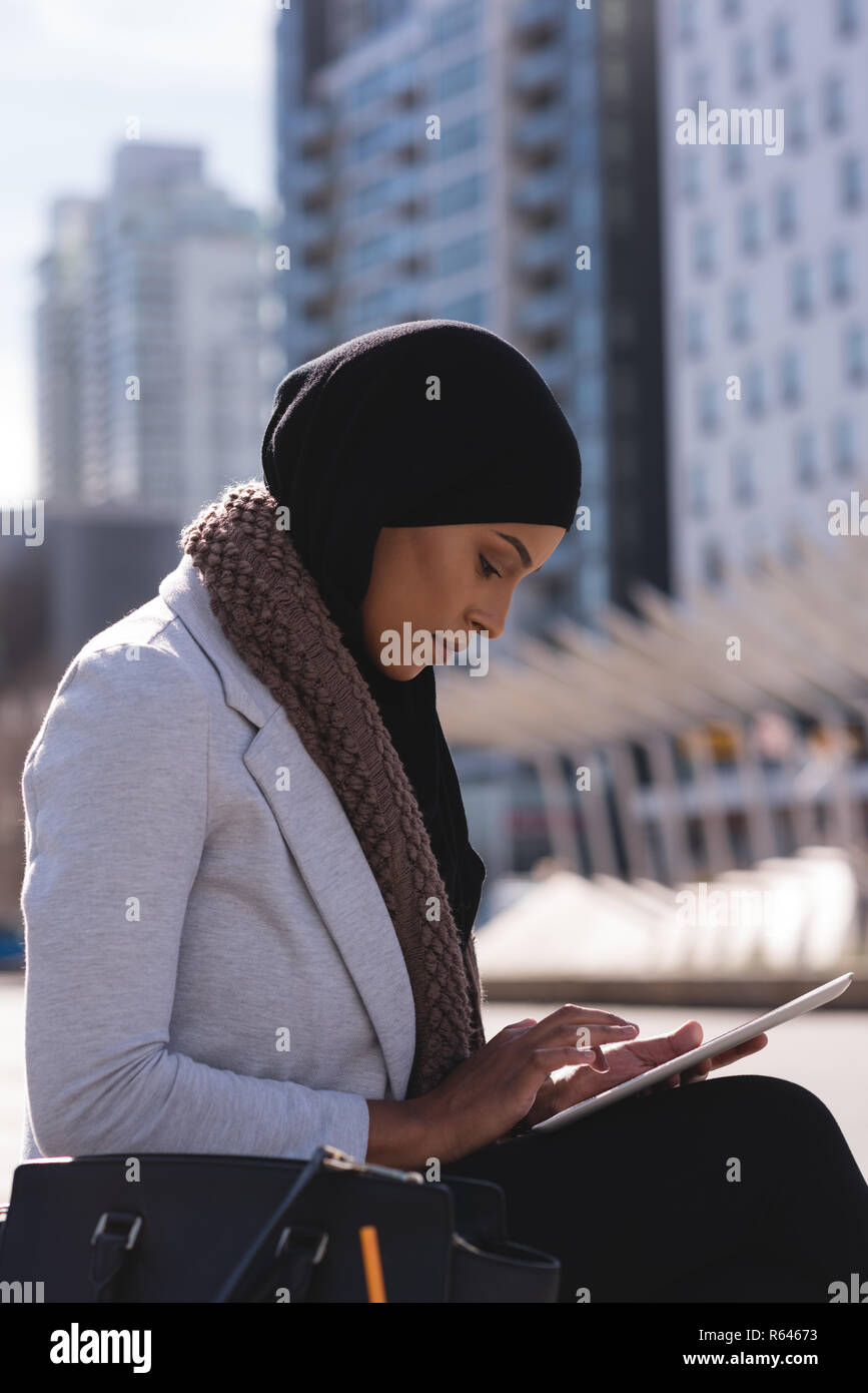 Hijab woman using digital tablet in city Stock Photo