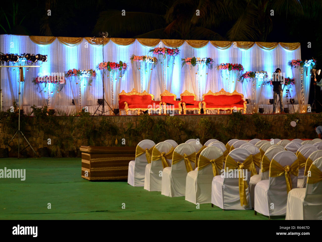 Big Indian fat wedding stage setup with chairs for the guests facing the stage for the bride and groom in a farmhouse in Delhi, India. Stock Photo