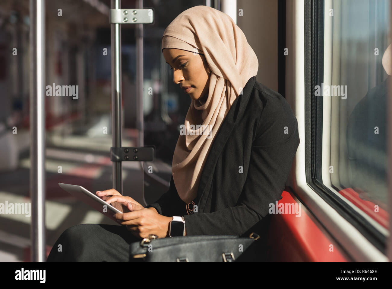 Woman using digital tablet while travelling in train Stock Photo