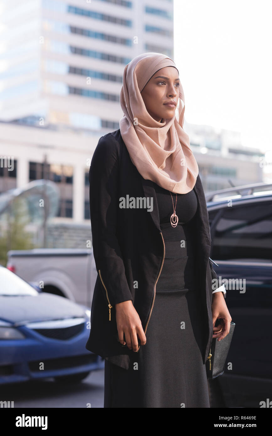 Hijab woman walking in city street Stock Photo