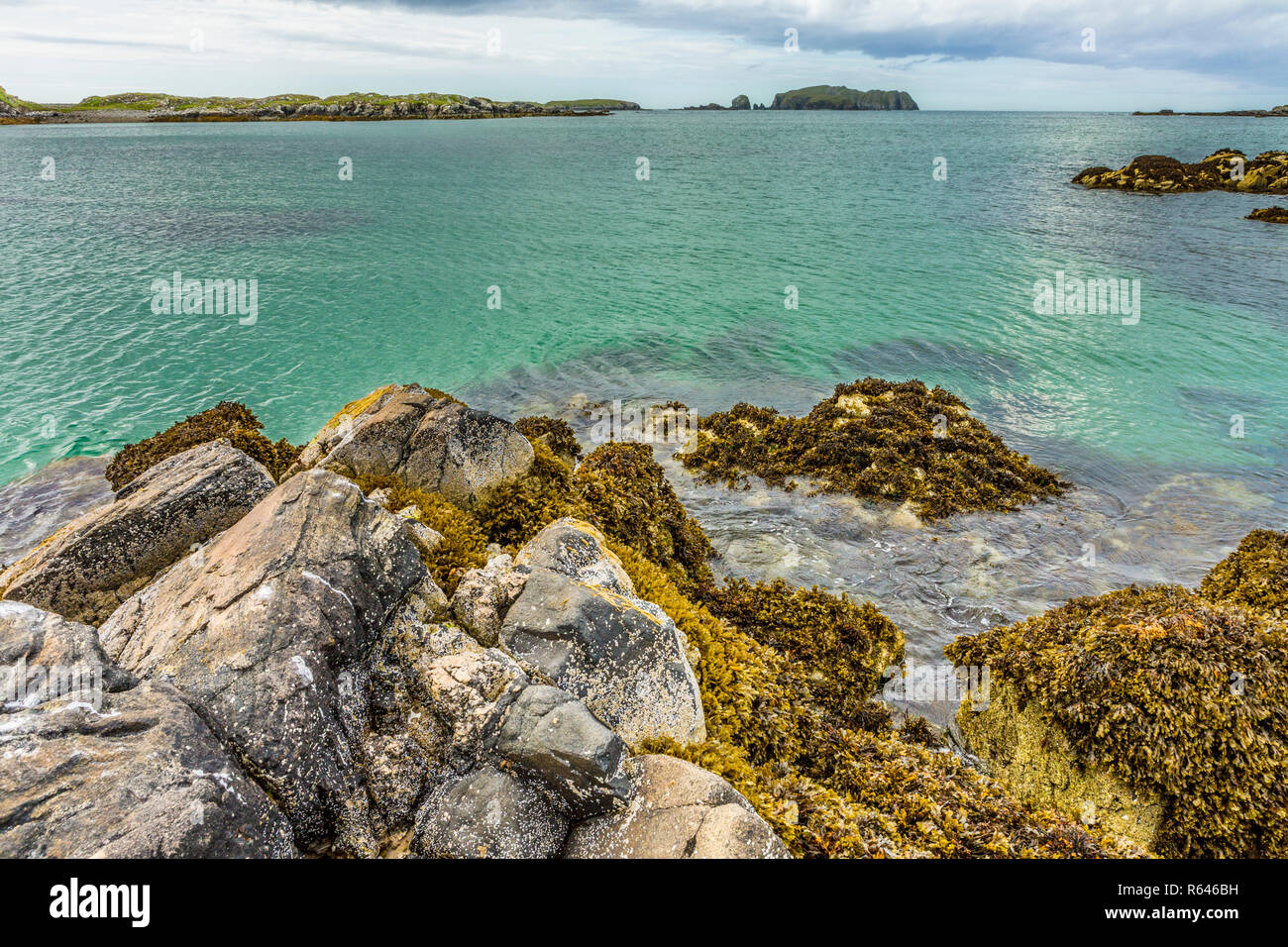 Seascape of rocks, seaweed and clear turquoise water at Bosta Beach, Great Bernera, Isle of Lewis, Outer Hebrides, Scotland, UK Stock Photo